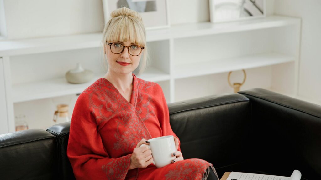 Female therapist sits on a couch.