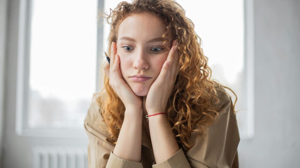 Woman with curly hair looks confused.
