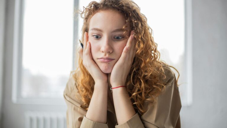 Woman with curly hair looks confused.