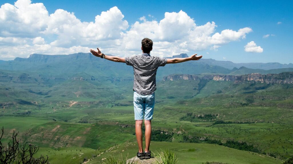 man opens arms to horizon