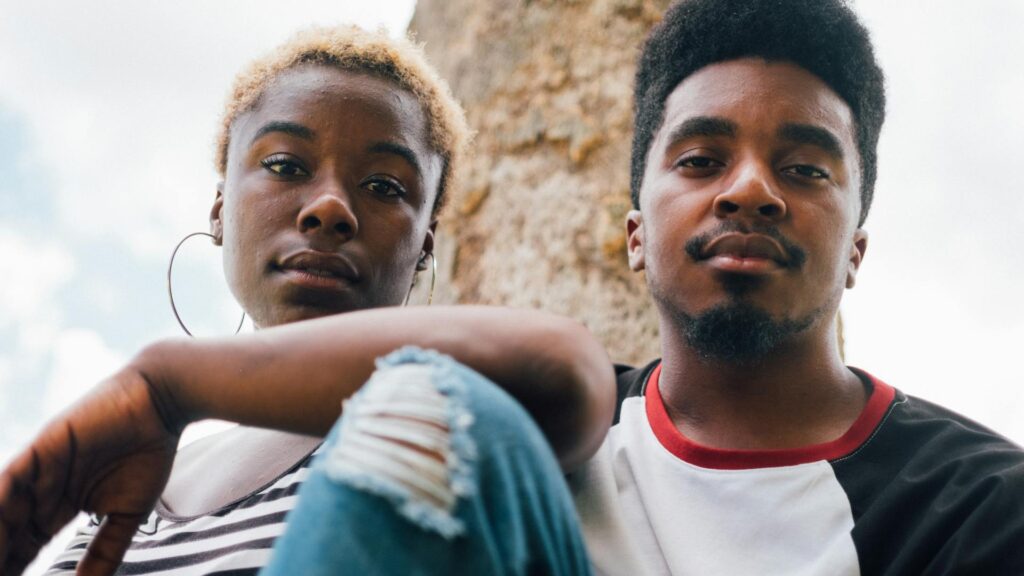 Black couple looks at camera.