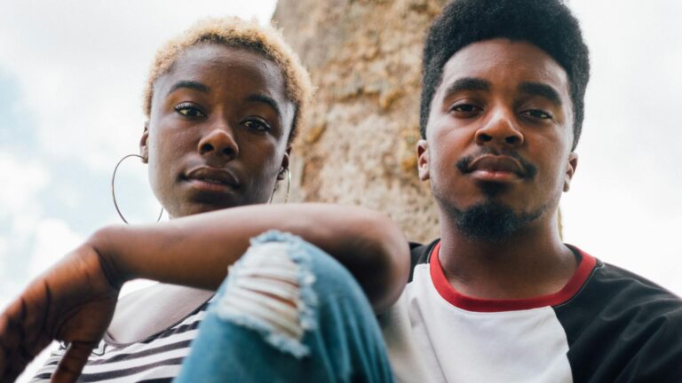 Black couple looks at camera.