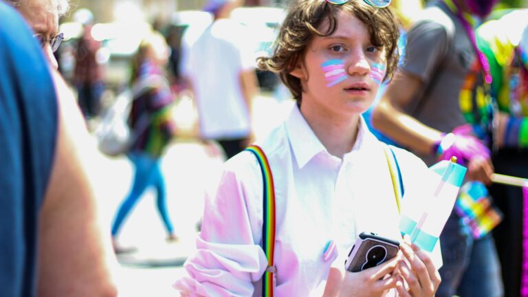 Young person with trans-pride facepaint at pride.